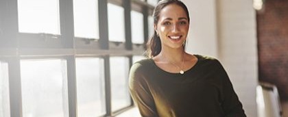smiling woman leaning against windowsill